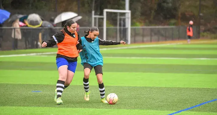 Sur la pelouse synthétique du terrain de la Marrière, à Nantes, deux jeunes footballeuses se disputent un  ballon lors d'un entraînement.