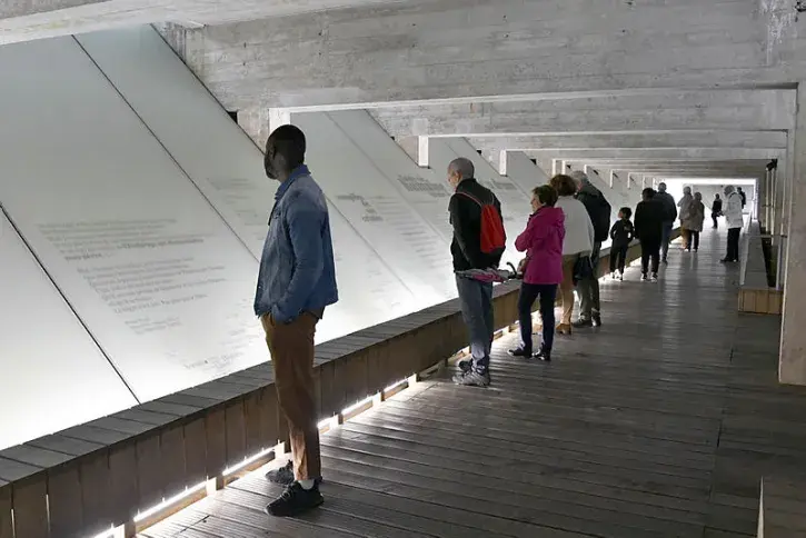 Des visiteurs observent le parcours méditatif du Mémorial. 