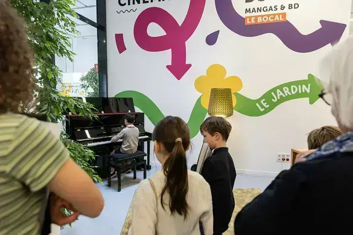 Une jeune fille est en train de jouer du piano à la médiathèque Lisa-Bresner