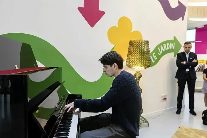 Un jeune est en train de jouer du piano.
