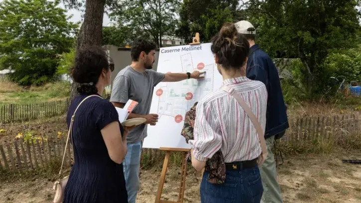 Des habitants découvrent la carte des projets qui sortent de terre dans le quartier de la caserne Mellinet à Nantes.