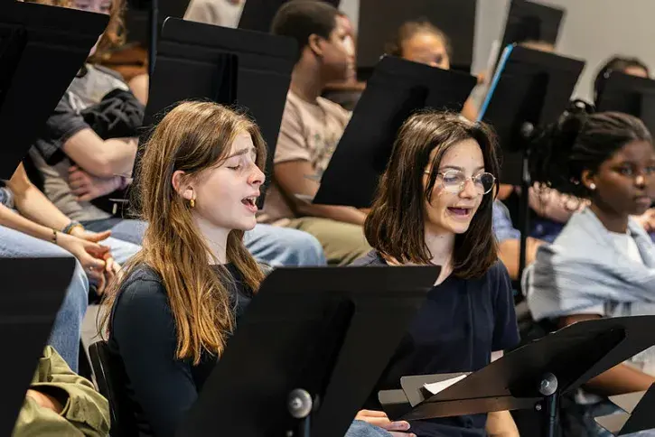 Des collégiens répètent un chant.