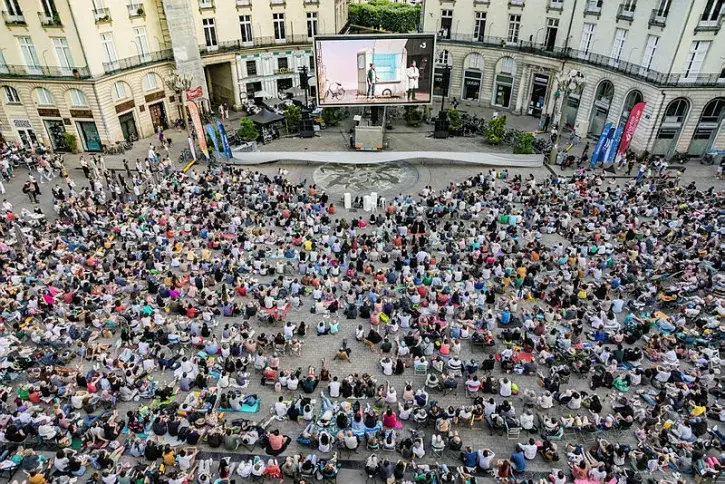 Des spectateurs observent un écran géant place Graslin.