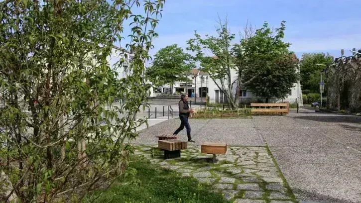 Un promeneur sur les nouveaux espaces végétalisés de la place de la Chapelle, à Bouguenais.