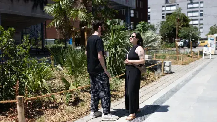 Deux personnes discutent devant les nouveaux espaces végétalisés dans le quartier de la création, à Nantes.
