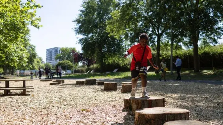 Un enfant s'amuse sur des rondins de bois, dans le nouveau square Colonel Atnaud-Beltrame, près de Beaulieu, à Nantes.