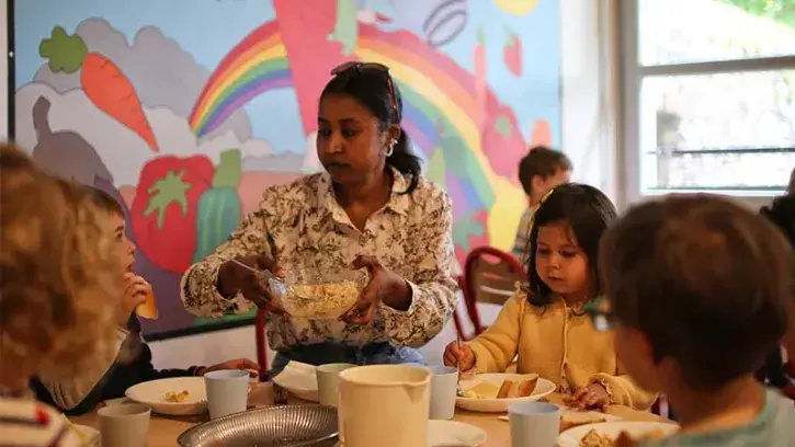 Les animatrices et animateurs déjeunent à la table des enfants.