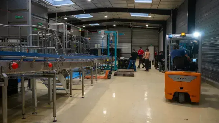 Un dernier robot remet les bouteilles et bocaux en palettes avant livraison aux producteurs de boissons. Pour les petites quantités ou les références particulières, du personnel emballe manuellement.