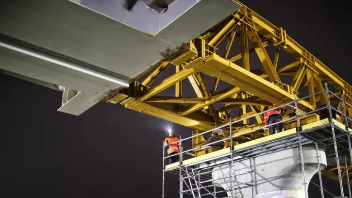 Les charpentiers ouvragistes au travail sur l'un des piliers du viaduc. Quatre nuits seront nécessaires pour que la charpente arrive sur la culée, dernier appui de l'ouvrage d'art.
