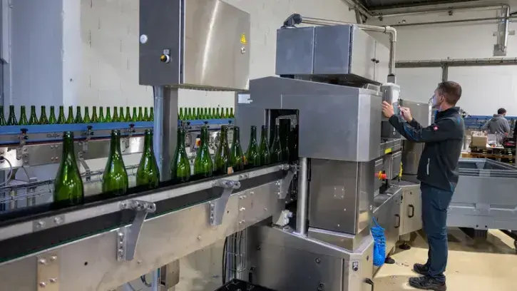 Une machine inspectrice (la 2e de France) vérifie ensuite chaque bouteille, grâce à douze caméras. Elle envoie les abîmées à la poubelle, les mal lavées retournent à la laveuse et les autres sont triées par forme et couleur pour rejoindre le bon quai d'em