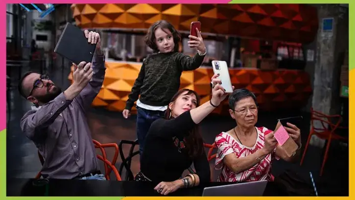 Quatre personnnes d'âges différents examinent leur smartphone ou ordinateur. © Romain Boulanger