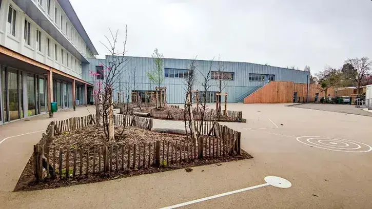 Un nouveau bâtiment (ici à droite), en bois et zinc, a été construit à la place de l'ancienne restauration. Il vient connecter l'école élémentaire (à gauche) et l'école maternelle.