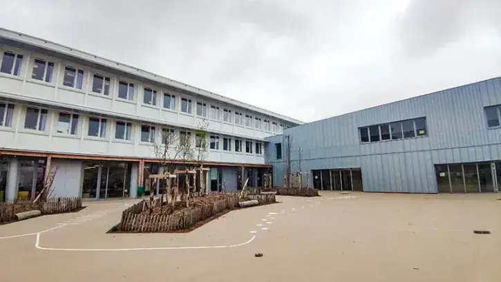 Un nouveau bâtiment (ici à droite), en bois et zinc, a été construit à la place de l'ancienne restauration. Il vient connecter l'école élémentaire (à gauche) et l'école maternelle.  © Garance Wester
