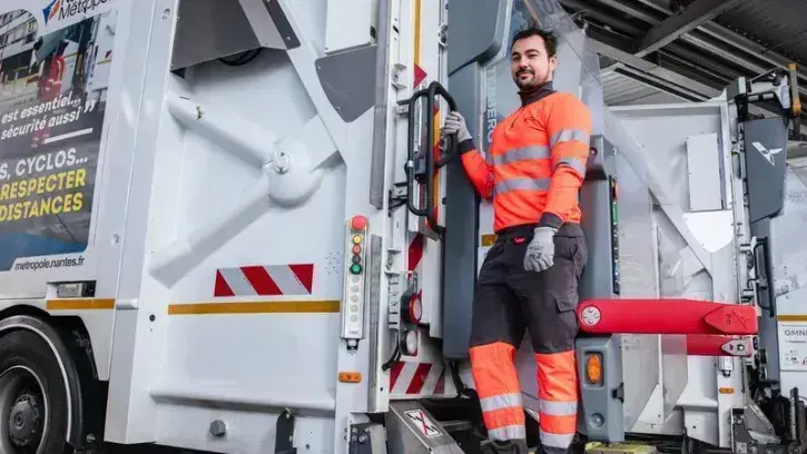 Clément, ripeur à l'arrière de son camion. ©Céline Jacq