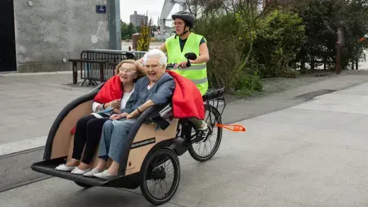 Deux seniors en compagnie d'une conductrice bénévole de triporteurs ©Céline Jacq